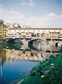 Bridge over river in city against sky