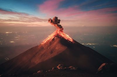 Digital composite image of volcanic landscape against sky during sunset