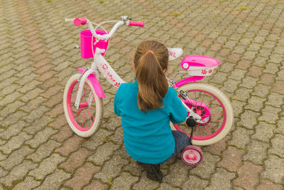 High angle view of girl with bicycle on street