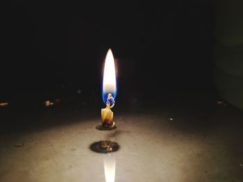 Close-up of lit candle in the dark