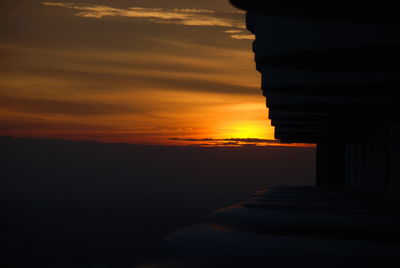 Low angle view of man standing against sky during sunset