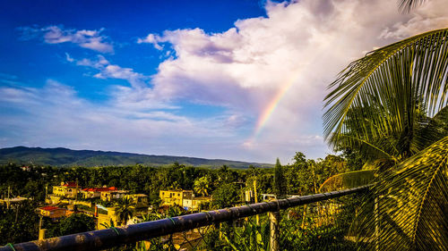 Scenic view of rainbow over landscape against sky