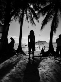 Silhouette people walking on beach