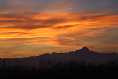 Scenic view of silhouette mountains against orange sky