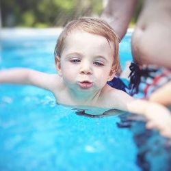 Portrait of cute boy swimming in pool