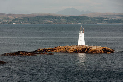 Small lighthouse on a rocky island off the coast of mallaig, scotland.