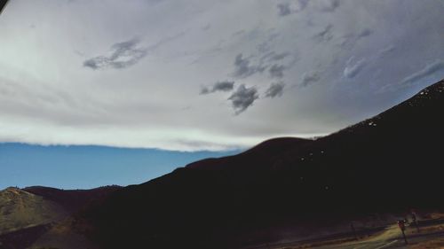 Scenic view of mountains against cloudy sky