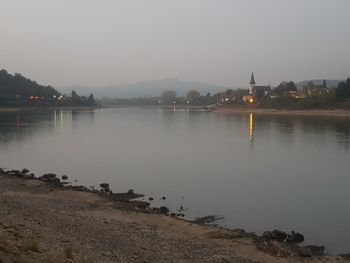 Scenic view of lake against clear sky at dusk