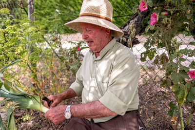 Midsection of man sitting by plants