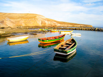 Boats moored in sea against sky