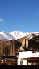 Houses against clear blue sky during winter