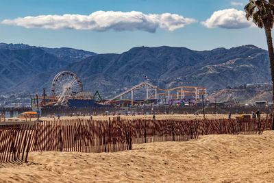 View of amusement park against cloudy sky