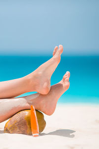 Midsection of woman relaxing on beach