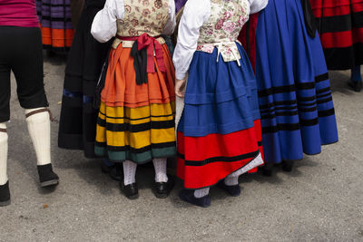 Low section of people in traditional clothing standing on road