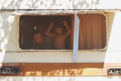 Portrait of father with son seen through motor home window