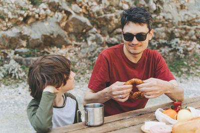 Father hugs his school boy son on family picnic. child kid and his dad taking a rest picnic hiking.