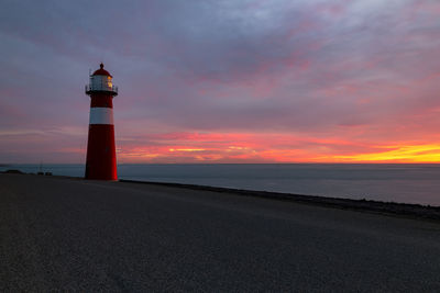 Small lighthouse westkapelle on the north sea at sunset, netherlands
