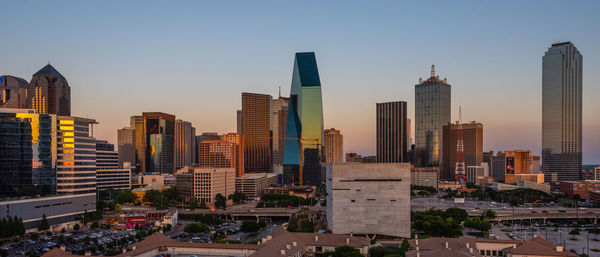 Modern buildings against clear sky during sunset