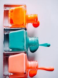 Close-up of orange bottle against blue background