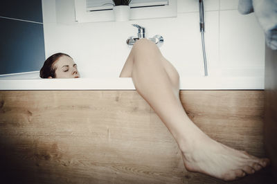 Woman relaxing in bathtub at bathroom