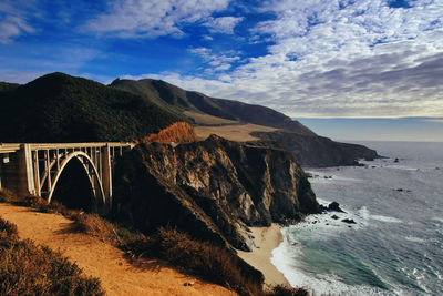 Arch bridge over sea against sky