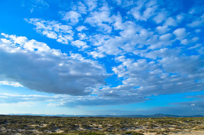 Low angle view of landscape against blue sky