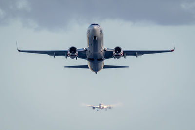 Low angle view of airplanes flying against sky