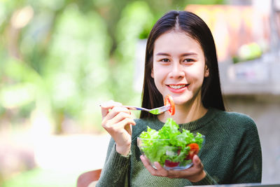 Portrait of young woman holding ice cream