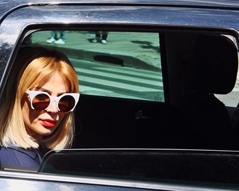 Portrait of young woman sitting in car