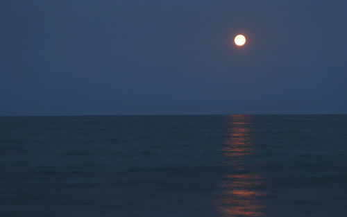 Scenic view of sea against clear sky at night