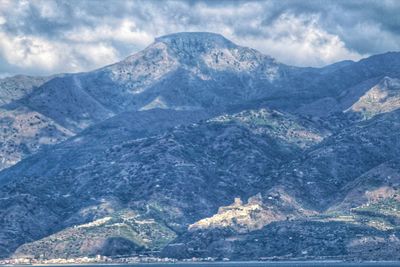 Scenic view of mountains against cloudy sky