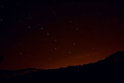 Low angle view of silhouette field against sky at night