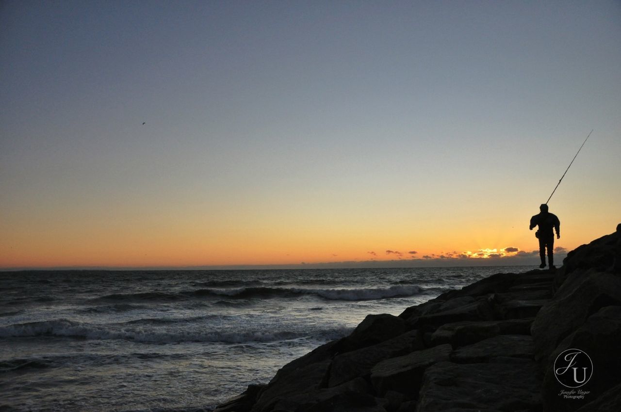 sea, lifestyles, water, men, horizon over water, leisure activity, sunset, silhouette, copy space, full length, standing, clear sky, scenics, beauty in nature, tranquil scene, rear view, nature, tranquility