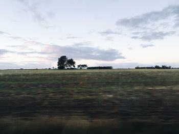 Scenic view of field against cloudy sky