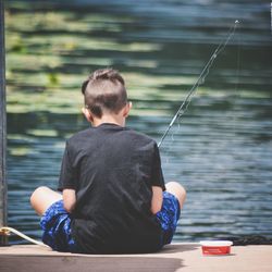 Rear view of man fishing at lake