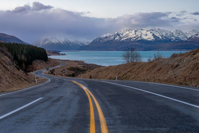 Mount cook road alongside lake pukaki with snow capped southern alps in winter evening light. 