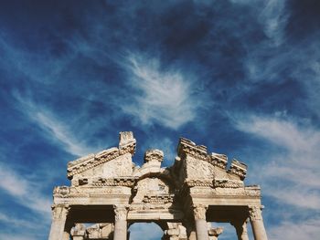 Low angle view of old ruins against cloudy sky