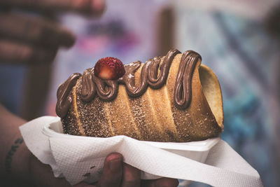 Close-up of hand holding cake