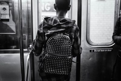 Rear view of man standing in train