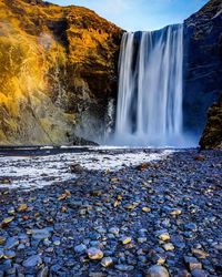 Scenic view of waterfall against sky