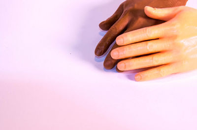 Close-up of woman hand over colored background