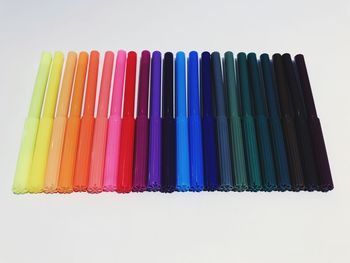 High angle view of multi colored pencils against white background