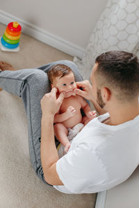 Father with baby girl sitting at home