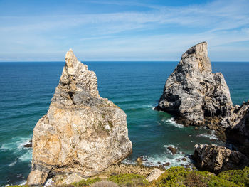 Rock formation on sea against sky