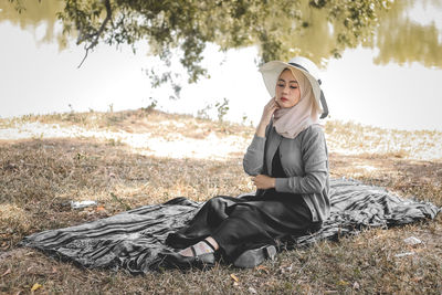 Young woman sitting on field