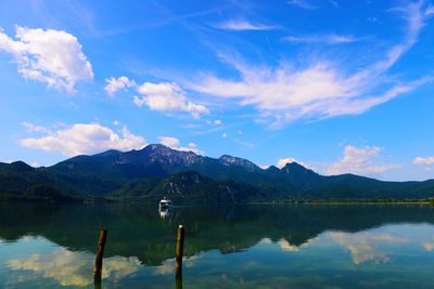 Scenic view of lake and mountains against blue sky