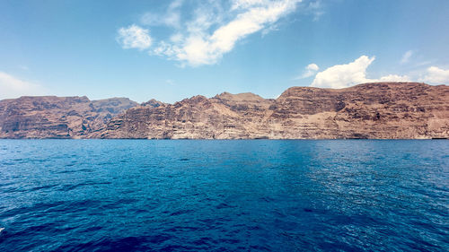 Scenic view of sea and mountains against sky