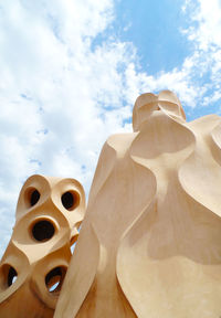 Sculptures in city against cloudy sky