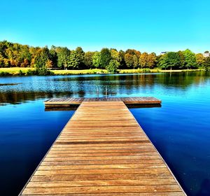 Scenic view of swimming pool by lake against clear sky