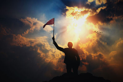 Rear view of silhouette man standing against sky during sunset